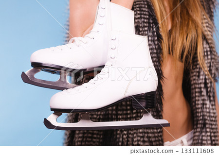 Woman wearing bra and holding ice skates 133111608