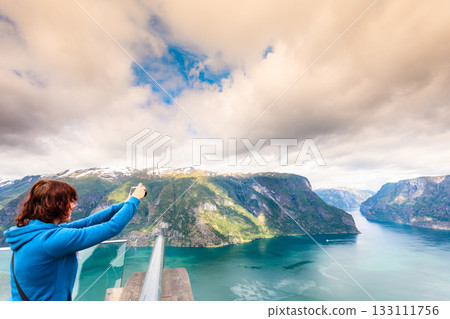 Tourist taking photo from Stegastein viewpoint Norway Tourist taking photo from Stegastein viewpoint Norway 133111756