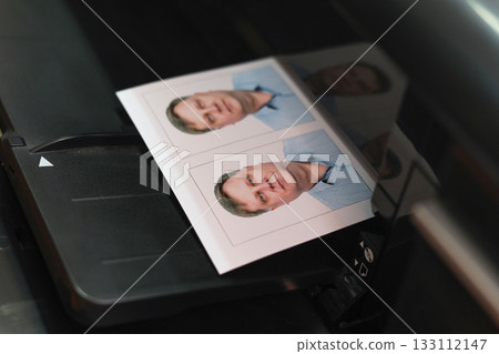 Printing documents on a printer. Photo studio service - creating photos for passports, passes, and ID cards Printing documents on a printer. Photo studio service - creating photos for passports, passes, and ID cards 133112147