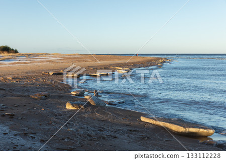 Scenic view of melting ice formations laying along the shoreline. Gulf of Finland in winter 133112228