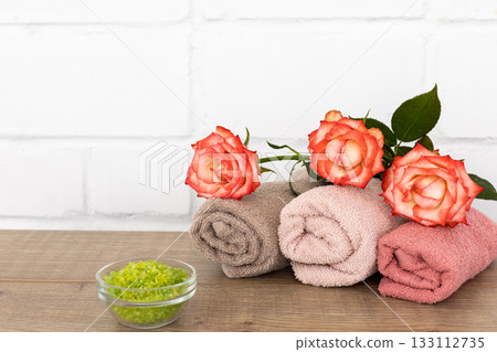 Spa composition with towels, flowers and sea salt on the wooden boards. Spa composition with towels, flowers and sea salt on the wooden boards. 133112735