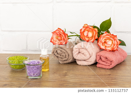 Spa composition with towels, flowers, sea salt and soap on the wooden boards. Spa composition with towels, flowers, sea salt and soap on the wooden boards. 133112737