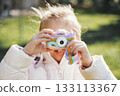 Child Taking Photos with Toy Camera in Playground 133113367