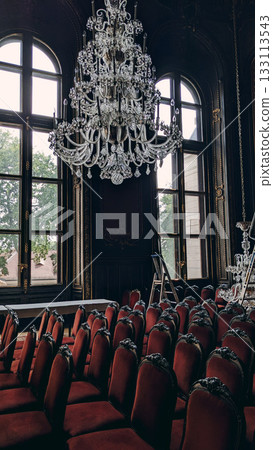 Historic Hall with Chandelier and Velvet Chairs 133113543