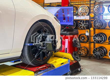 Car wheel alignment on stand with sensors check in service station. Vehicle inside garage workshop for auto camber fixing work, Vehicle inside garage workshop. Car wheel alignment on stand with sensors check in service station. Vehicle inside garage workshop for auto camber fixing work, Vehicle inside garage workshop. 133114299