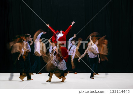 Red-jacket leader rising above team in intense motion blur choreography symbolizing conflict and alignment Red-jacket leader rising above team in intense motion blur choreography symbolizing conflict and alignment 133114445