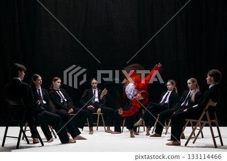 Blurred dynamic jump of person in red jacket surrounded by seated group symbolizing breakthrough and innovation Blurred dynamic jump of person in red jacket surrounded by seated group symbolizing breakthrough and innovation 133114466