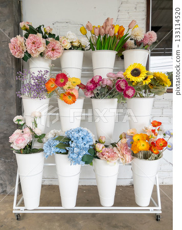 Vibrant Artificial Flowers Display on White Shelf. 133114520