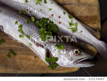 Fresh European hake fish on wooden board with parsley, Raw uncooked Merluccius merluccius topview 133114947