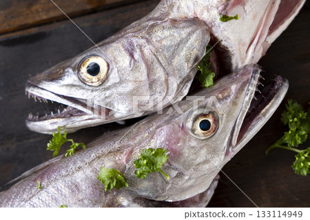Fresh European hake fish on wooden board with parsley, Raw uncooked Merluccius merluccius topveiw 133114949