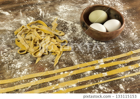 Yellow dough with ingredients on the table, homemade italian food. 133115153