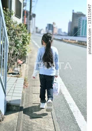 (面向未來的勢頭)一個孩子走在筆直的道路上,白線與道路交會。 (面向未來的勢頭)一個孩子走在筆直的道路上,白線與道路交會。 133115647