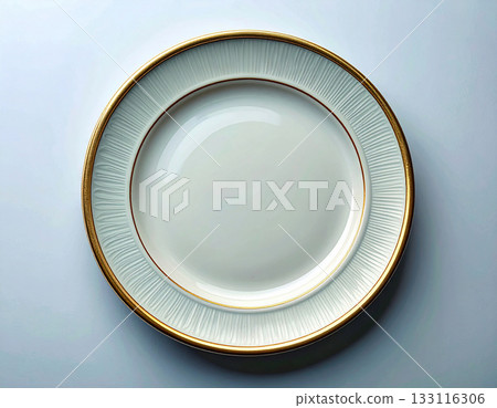 Elegant table setting. Ceramic plate with a classic white and gold design on a white background. Porcelain kitchenware. Close-up. Top view. Elegant table setting. Ceramic plate with a classic white and gold design on a white background. Porcelain kitchenware. Close-up. Top view. 133116306