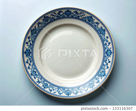 Elegant patterns. Ceramic plate with a classic white and blue pattern on a white background. Porcelain kitchenware. Close-up. Top view. Elegant patterns. Ceramic plate with a classic white and blue pattern on a white background. Porcelain kitchenware. Close-up. Top view. 133116307