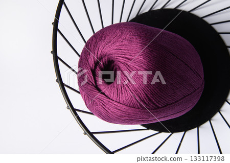 Purple yarn in a metal basket on a white background. Web banner for creative goods. 133117398