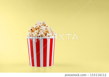 Classic red striped popcorn cardboard cup on Yellow background 133118112