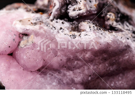 Macro pink Smithsonite mineral stone on microcline on black background Macro pink Smithsonite mineral stone on microcline on black background 133118495