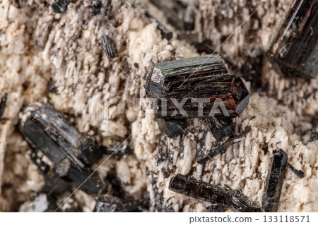 Macro mineral stone Schorl, Black Tourmaline on the feldspar on a white background Macro mineral stone Schorl, Black Tourmaline on the feldspar on a white background 133118571