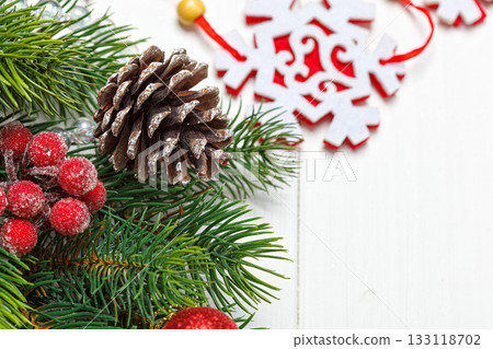 Christmas composition, Christmas tree branch with toys, cones on a wooden background 133118702
