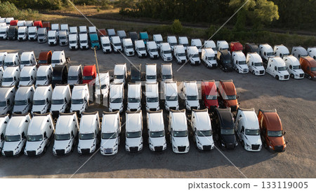 A group of trucks parked in a large lot, rows of vehicles under a clear sky, A group of trucks parked in a large lot, rows of vehicles under a clear sky, 133119005