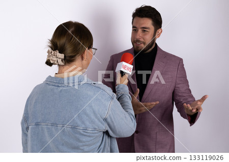 A journalist is interviewing a man with a microphone A journalist is interviewing a man with a microphone 133119026