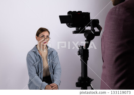 Woman is being filmed for what could be a journalistic interview or report Woman is being filmed for what could be a journalistic interview or report 133119073