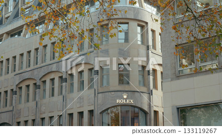 Luxury watch store displaying elegant architecture in a vibrant city during autumn 133119267