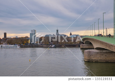 View of riverside buildings and bridge in a city during overcast evening hours View of riverside buildings and bridge in a city during overcast evening hours 133119331