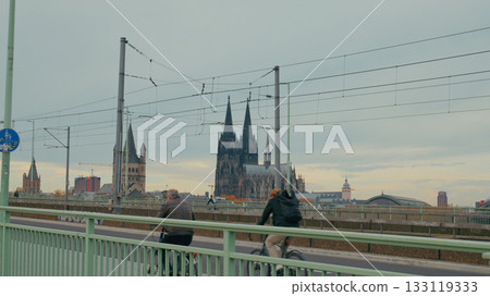Cyclists enjoying a ride near Cologne Cathedral on an overcast day in Germany Cyclists enjoying a ride near Cologne Cathedral on an overcast day in Germany 133119333
