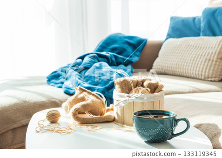 Knitting Setup with Yarn Basket, Mug, and Cozy Couch in Sunlight Knitting Setup with Yarn Basket, Mug, and Cozy Couch in Sunlight 133119345
