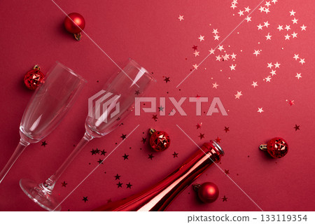 Red Holiday Celebration with Champagne Flutes, Bottle, and Ornaments Red Holiday Celebration with Champagne Flutes, Bottle, and Ornaments 133119354