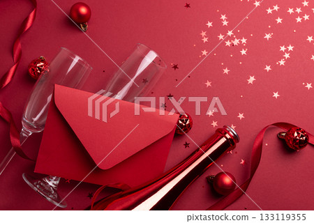 Red Holiday Celebration with Champagne Flutes, Bottle, Ribbon, Ornaments and Red Envelope for congratulation 133119355