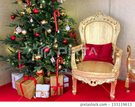 Santas golden chair near decorated Christmas tree 133119613