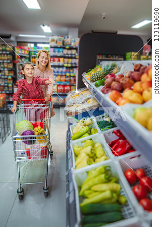 Mother and daughter grocery shopping for healthy food 133119690