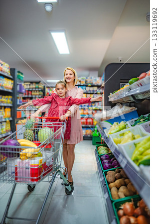 Mother and daughter having fun while grocery shopping in supermarket Mother and daughter having fun while grocery shopping in supermarket 133119692