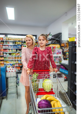 Mother and daughter shopping for healthy groceries in supermarket 133119697