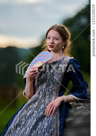 Portrait of a young redhead girl in Victorian style dress posing beside castle Portrait of a young redhead girl in Victorian style dress posing beside castle 133120029
