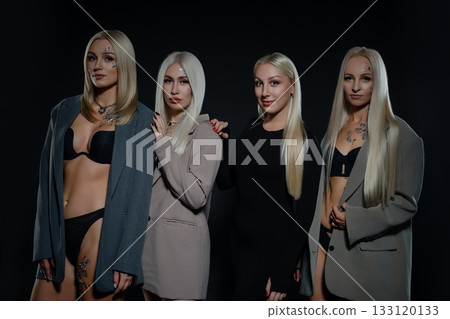 Group of models in stylish outfits posing against a dark background at night 133120133