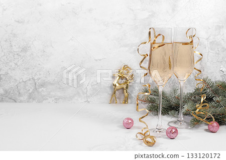 Two glasses of champagne on an elegant festive background with fir branches and decorations, a Christmas Eve concept. Christmas and New Year's mockup for design and product display. Happy New Year Two glasses of champagne on an elegant festive background with fir branches and decorations, a Christmas Eve concept. Christmas and New Year's mockup for design and product display. Happy New Year 133120172
