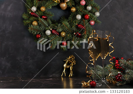 Champagne, holiday decorations, and a fir wreath with a deer figurine on an elegant background, Christmas Eve concept. New Year's card, banner for display, Happy New Year Champagne, holiday decorations, and a fir wreath with a deer figurine on an elegant background, Christmas Eve concept. New Year's card, banner for display, Happy New Year 133120183