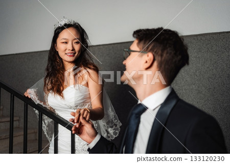 Interracial couple holding hands on wedding day 133120230