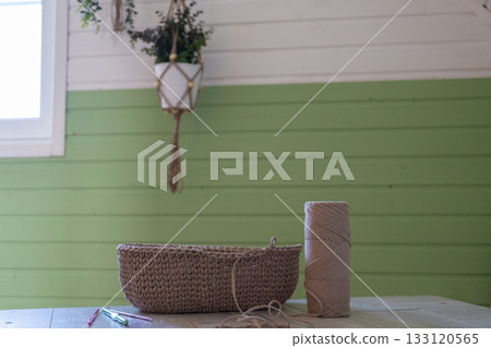 Cozy room with green accents and craft supplies on wooden table Cozy room with green accents and craft supplies on wooden table 133120565
