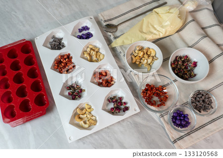 Homemade chocolate making kit with nuts and dried fruits on kitchen counter 133120568