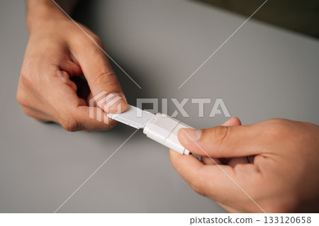 Closeup male hands inserting micro sd card into usb adapter, enabling data transfer and storage expansion on minimalist gray surface. Concept of computer hardware 133120658