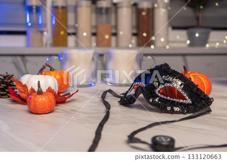 Festive halloween kitchen scene with pumpkins and masquerade mask Festive halloween kitchen scene with pumpkins and masquerade mask 133120663