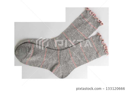 Cozy gray socks with pink stripes and ruffled edges on white background Cozy gray socks with pink stripes and ruffled edges on white background 133120666