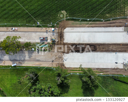 Construction of a new road segment in a green area during a sunny day 133120927