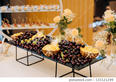 Elegant fruit platter with pineapple, grapes and cherries at a catered event 133121299
