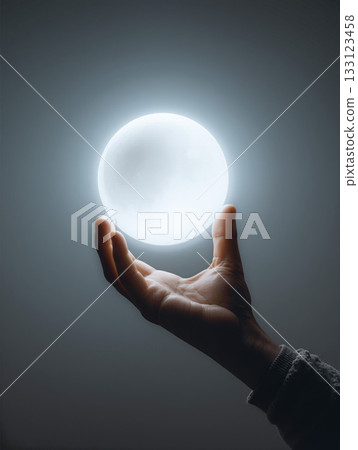 Hand holds glowing orb that appears to float in a dark space, creating a mystical atmosphere 133123458
