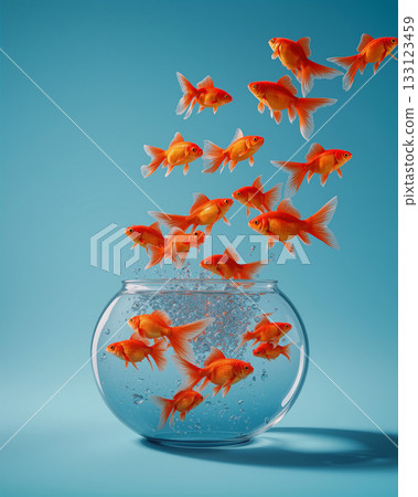 Goldfish leap from bowl into bright blue background, showcasing playful energy in a whimsical scene 133123459